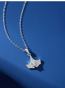 Gros plan d'un collier pendentif feuille de ginkgo en argent serti de zircons brillants