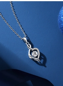Macro shot of silver heart and infinity pendant with sparkling center round moissanite