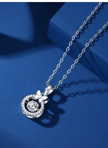 Detail shot of a silver bow necklace featuring a central moissanite stone and halo diamonds