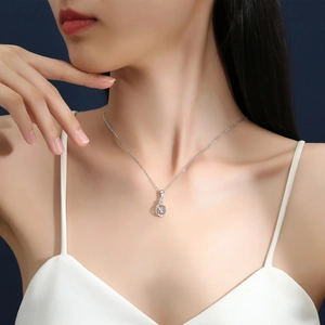 Elegant S925 sterling silver moissanite dancing heart necklace on model with blue backdrop