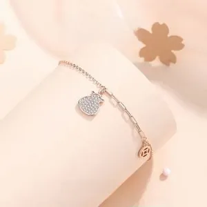 Vue macro du bracelet en argent S925 avec pendentifs sac de chance et pièce rosée