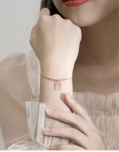 Detail of rose gold lucky cat bracelet with sparkling zircon pavé on model's wrist