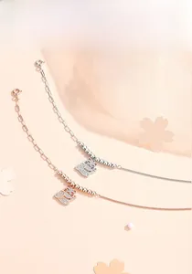 Detail of silver and rose gold lucky cat bracelets with white zircon pave setting