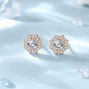 Macro shot of rose gold star stud earrings with white shell and sparkling zircons