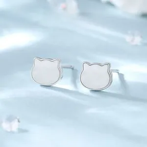 Macro detail of S925 sterling silver cat silhouette stud earrings on blue silk