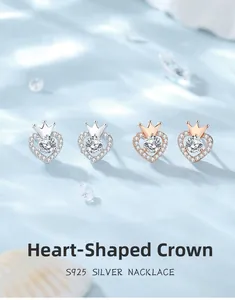 Macro shot of S925 sterling silver heart crown stud earrings in silver and rose gold