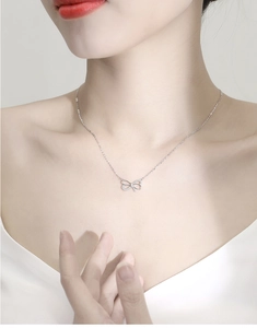Gros plan du collier nœud élégant en argent S925 avec cristaux étincelants sur mannequin