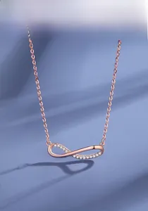 Dettaglio del ciondolo infinito in oro rosa con pavé di pietre di zirconia scintillanti