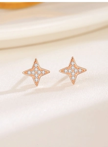 Macro shot of rose gold four-point star stud earrings set with sparkling zircons