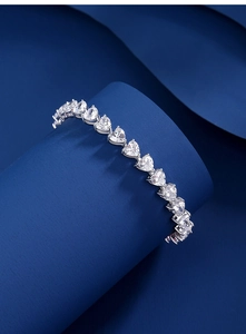Makroaufnahme von S925 Sterling Silber Herzschliff Moissanit Tennisarmband auf blauem Grund