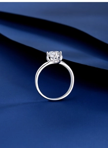Macro shot of S925 silver moissanite ring with six-prong crown setting on blue background