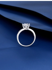 Makroaufnahme eines 1-Karat-Moissanit-Rings mit Seitensteinen auf dunkelblauer Seide