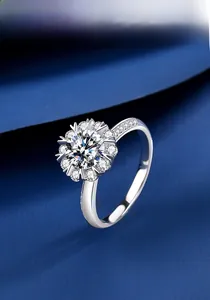 Détail de bague en argent S925 avec moissanite et halo flocon sur fond en tissu bleu