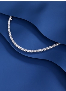 Detailed view of oval cut zircons on an S925 silver tennis bracelet with elegant blue background