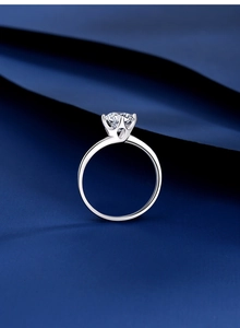 Detailed side view of a classic six-prong moissanite ring with a polished silver finish