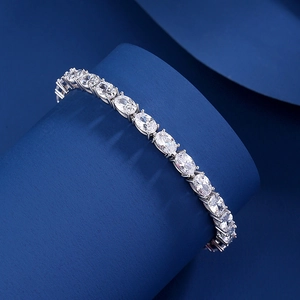 Classic S925 sterling silver tennis bracelet with oval-cut cubic zirconia on a blue pedestal
