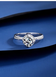 Macro shot of 1 carat moissanite ring with halo setting on artistic blue paper