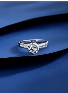 Macro d'une bague moissanite 1 carat avec serti quatre griffes sur fond bleu marine