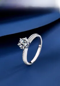 Close-up of a classic six-prong s925 silver moissanite ring with side accent diamonds