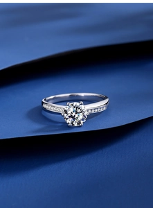 Macro view of six-prong crown moissanite silver ring with side-stone detailing