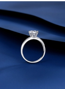 Detailed view of classic six-prong moissanite ring with side accent diamonds on silver band