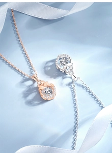 Detail of rose gold and silver swan pendant necklaces with sparkling central stones