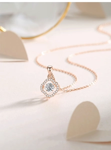 Detail of rose gold clover necklace with dancing moissanite center and pave zircons