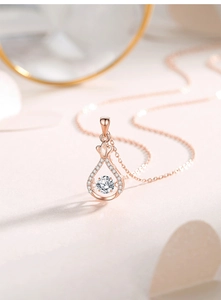 Détail du pendentif goutte d'eau or rose avec couronne et pierre de moissanite