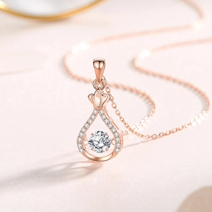 Élégant collier pendentif goutte en or rose avec moissanite mobile et détail couronne
