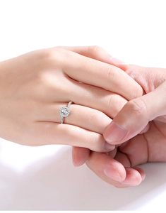 Close-up of S925 silver moissanite ring with halo setting on a couple hand