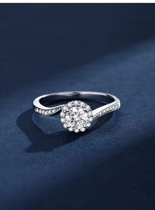 Détail macro d'une bague halo en moissanite avec anneau torsadé pavé sur fond bleu