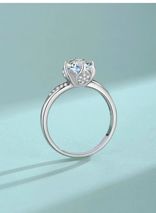Macro detail of lotus shaped moissanite ring with intricate pavé stones on silver band