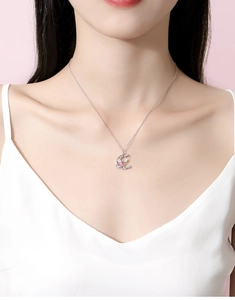 Gros plan du pendentif lune et étoile en argent S925 avec une pierre rose sur un mannequin