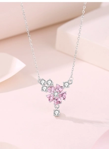 Vue macro du pendentif cerisier en argent S925 avec gemmes roses en cœur et diamants clairs