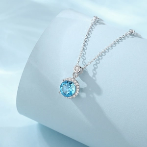 Collier en argent S925 avec pierre précieuse bleu clair sur présentoir bleu