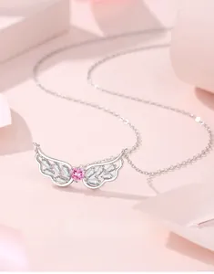 Close-up of S925 silver angel wing necklace with pink heart gem and zircon details