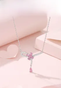 Dettaglio macro del ciondolo fiore di pesco argento con pietre preziose rosa e cristalli