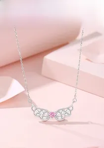 Detail of silver angel wing necklace with pink heart gemstone and sparkling white zircons