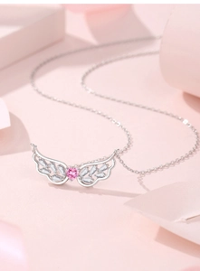 Detailed close-up of 925 sterling silver angel wing pendant with a pink heart gemstone