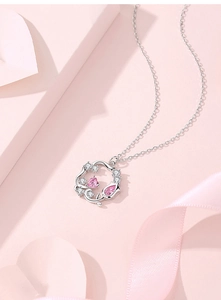 Makroaufnahme von Silberkranz-Anhänger mit rosa Herz-Edelstein und weißen Zirkonia