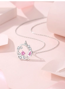 Detail einer silbernen Halskette mit rosa Herz- und tropfenförmigen Schmucksteinen