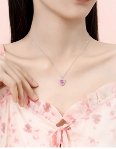 Dettaglio della collana con cristallo rosa a forma di cuore su modella e catena d'argento