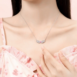 925 silver angel wing necklace featuring a pink heart stone pendant on a model