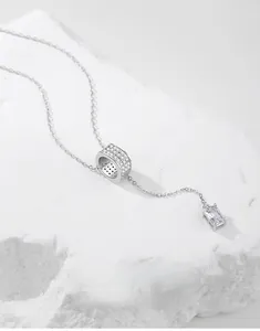 Detail view of S925 silver necklace with sparkling cylindrical bead and zircon tassel