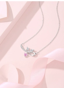 Makroaufnahme der S925 Silberkette mit glitzernder Schleife und rosa Herz-Anhänger