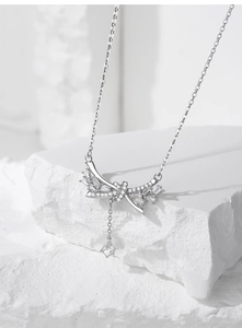 Détail du collier noeud en argent S925 avec zircons scintillants sur un support en pierre