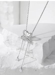 Vue détaillée du pendentif papillon argenté avec incrustation de zircon et chaînes à pampilles