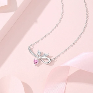 S925 Silberhalskette mit rosa Herzanhänger und Schleifendetails auf rosa Seidenhintergrund