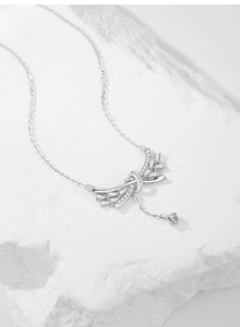 Vue macro d'un collier nœud en argent S925 avec diamants pavés et un pompon délicat