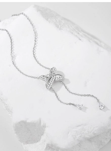 Détail du collier en argent S925 avec pendentif en X scintillant et chaînes à pompons